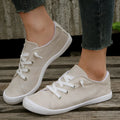 Women's creamy-white low-top fabric sneaker with rubber sole on a neutral background.