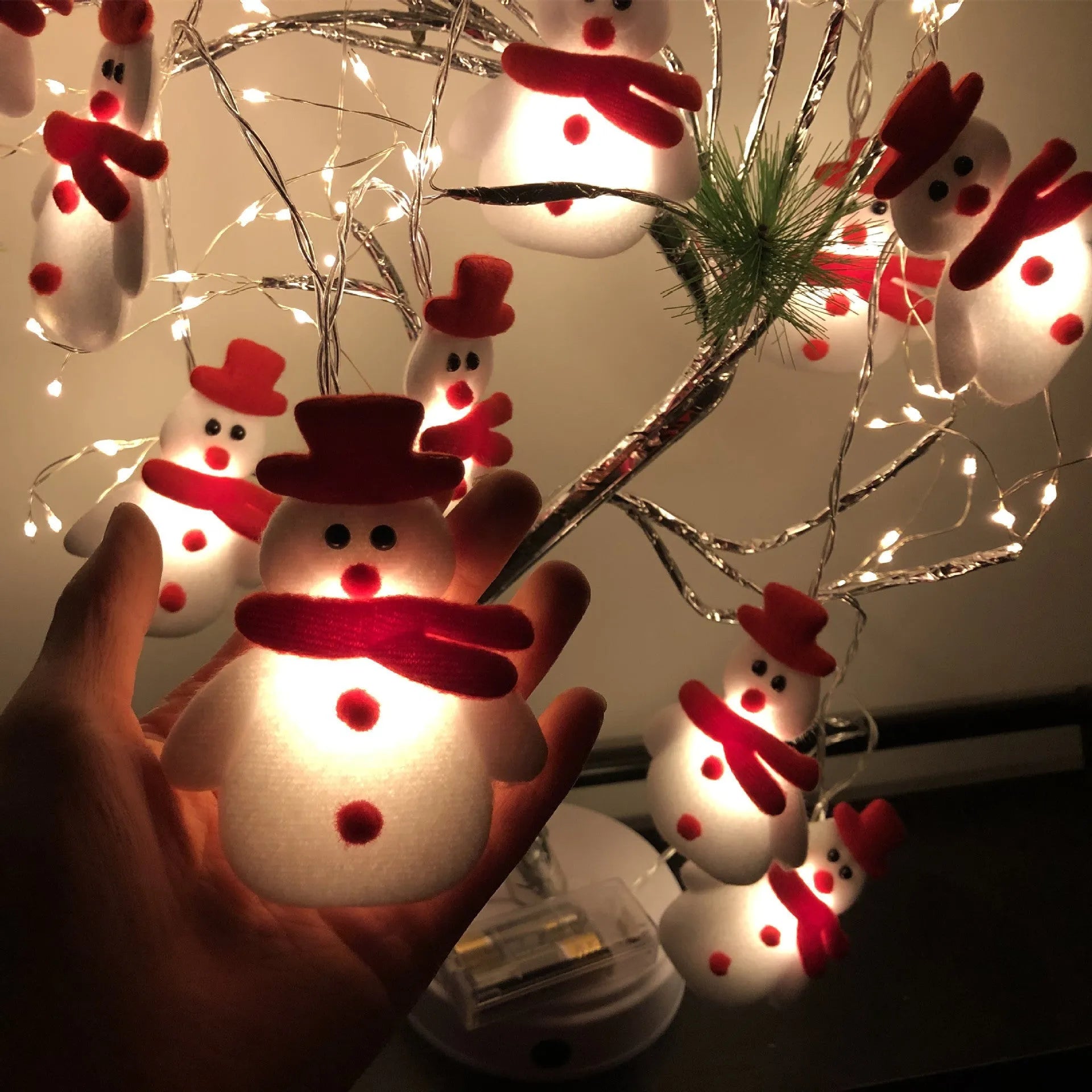 Warm white LED Christmas string lights with Snowman decorative figures on a green garland.