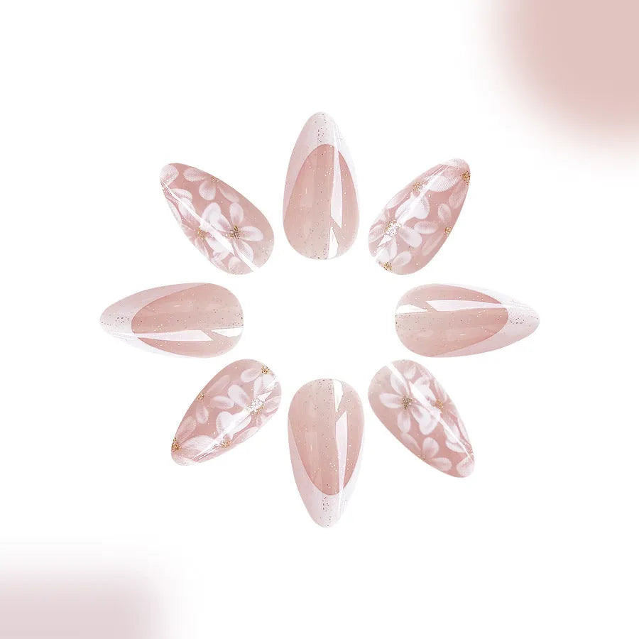 Short almond-shaped false nails with glossy French tip and glitter flower decoration, colour C625.
