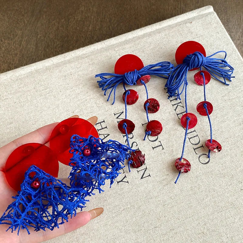 Geometric cloth earrings with blue resin flower detail and round design elements