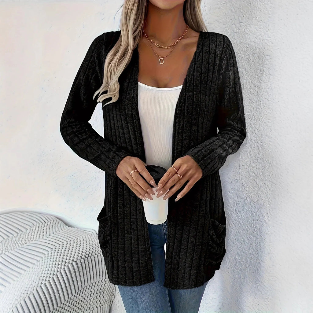Plus size woman wearing a long sleeve grey cardigan with front pockets, loose fit.