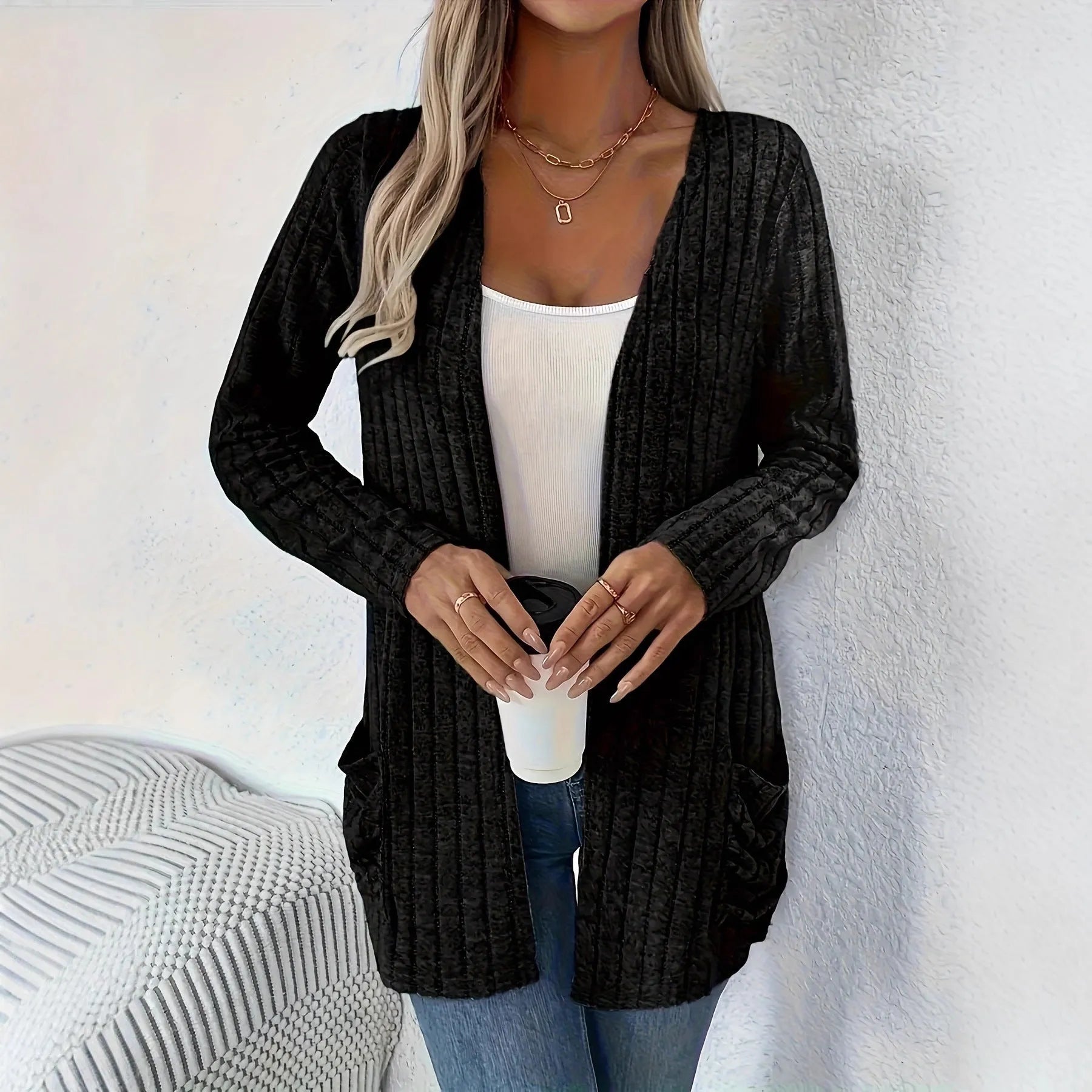 Plus size woman wearing a long sleeve grey cardigan with front pockets, loose fit.