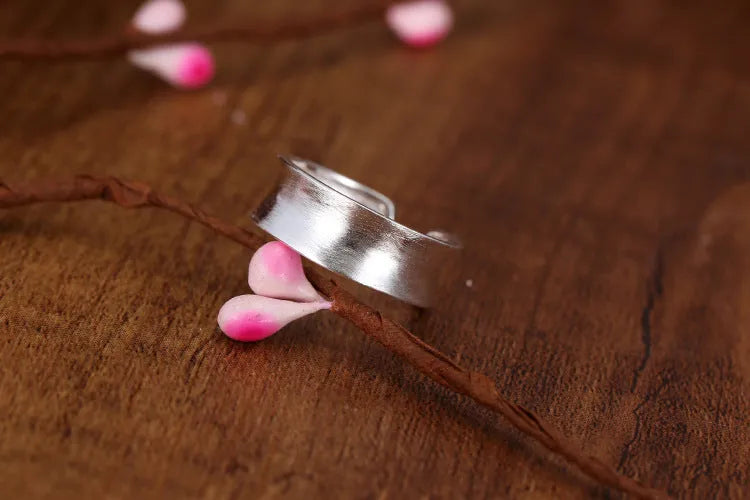 Open geometric ring in frosted sterling silver with an adjustable band.