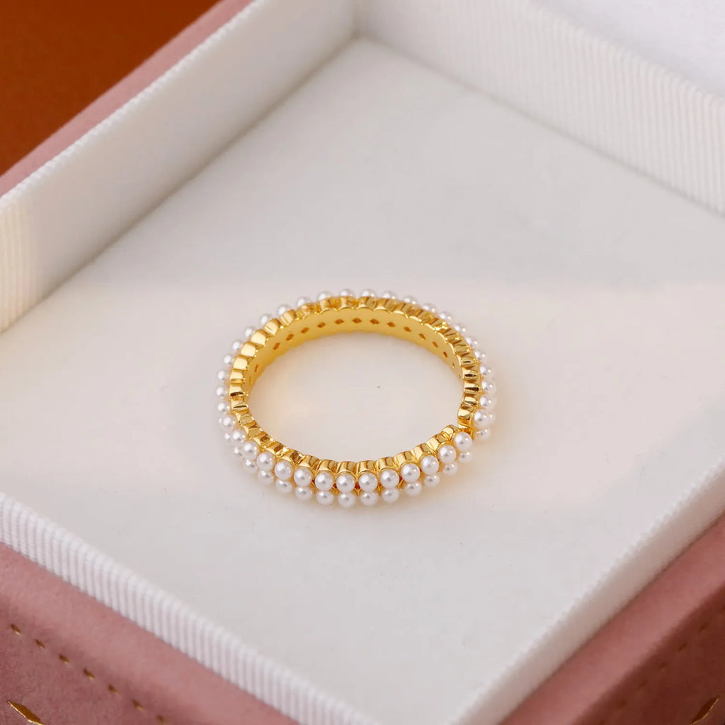 Gold electroplated open mouth geometry pearl ring for women on a neutral background.