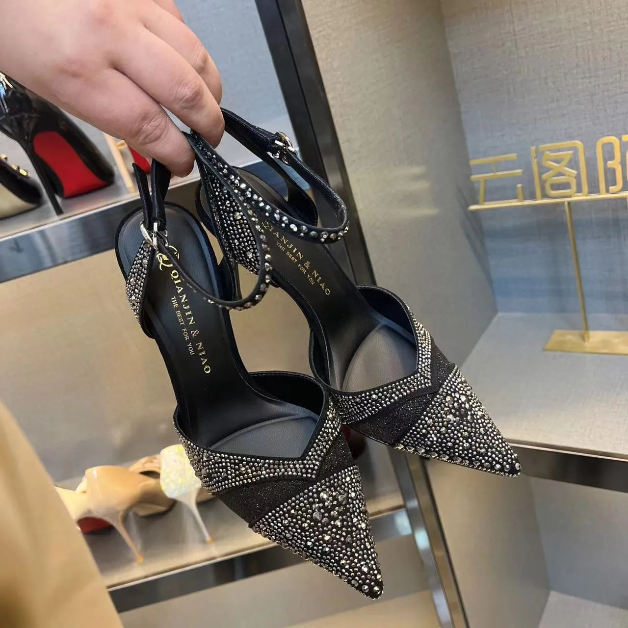 Women's black and silver hollow high heels with red soles, stiletto heels, and pointed toe design