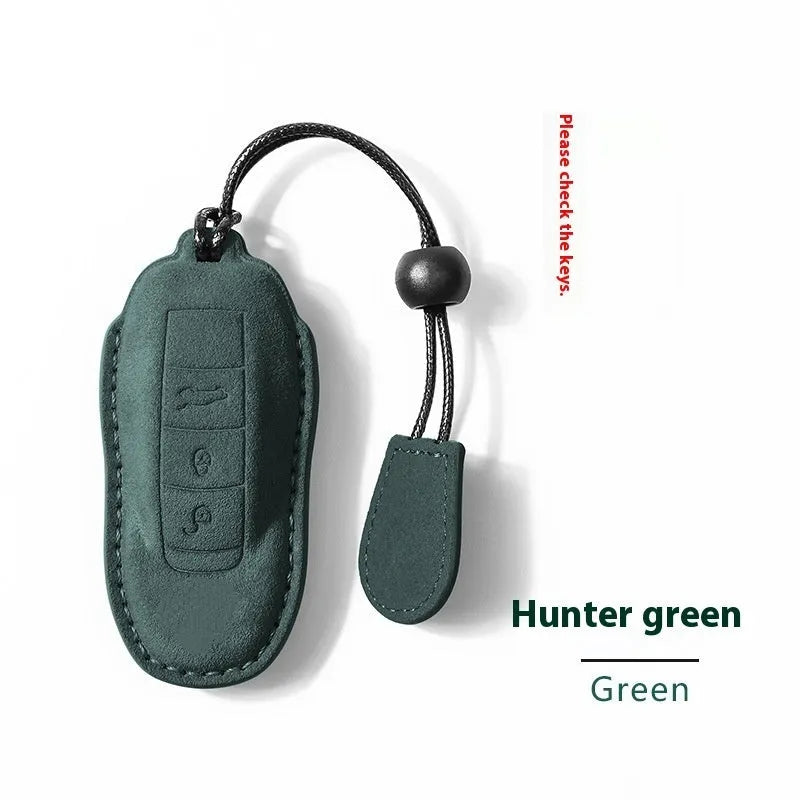 Suede car key cover in cement grey, dark green, light grey, and orange colour options.