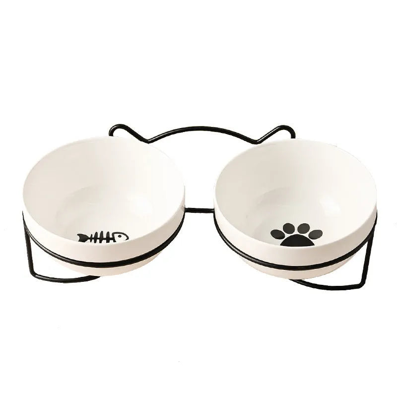 White ceramic cat bowl with cat paw print design on a black iron frame stand