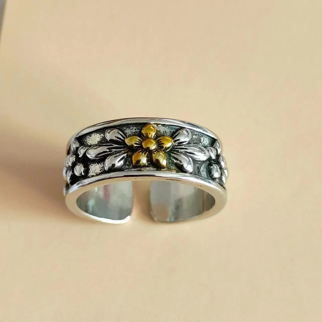 Vintage antique silver gold flower open ring with camellia floral design on a neutral background