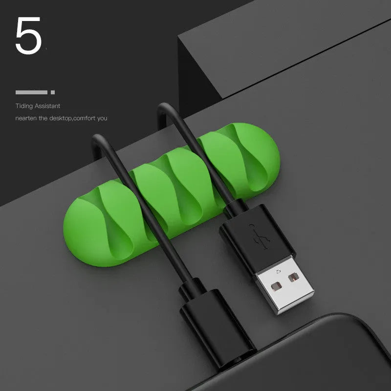 Smart cable holder with TPR flexible clips in black holding USB earphone and network cables on a desk