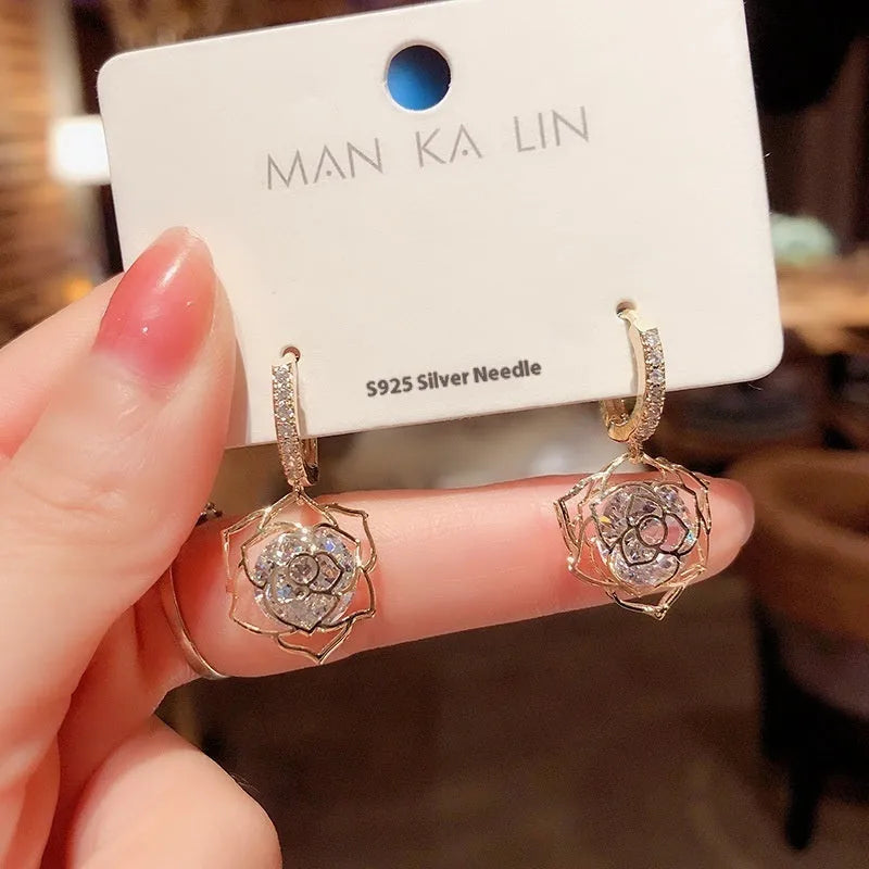 A pair of simple geometric rose-inspired earrings for women, made from electroplated copper, shown in one of the available colour types.
