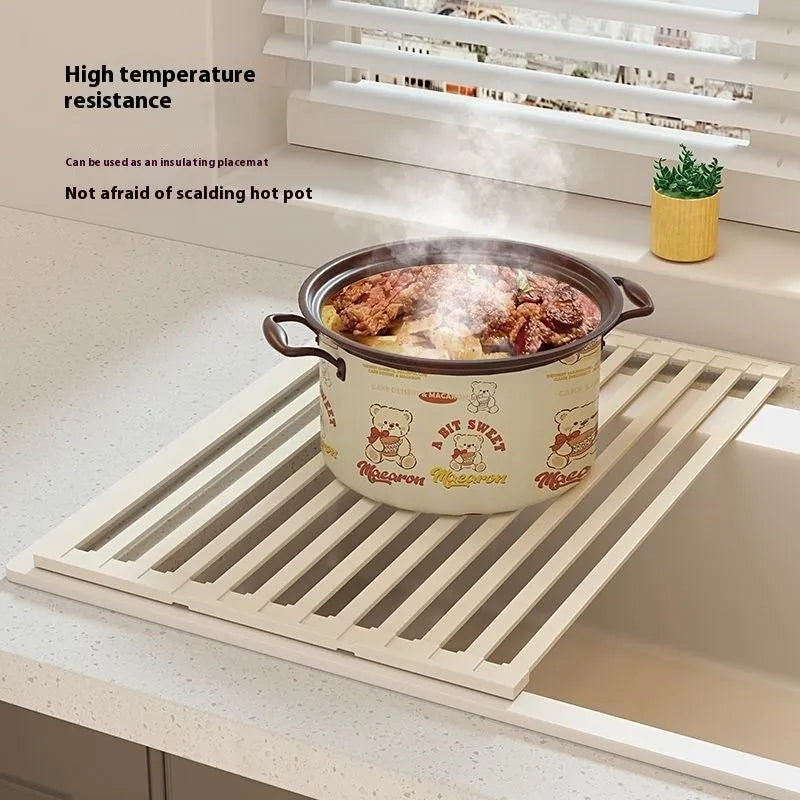 Milky white foldable stainless steel kitchen draining rack shown in a sink.