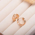 Rose gold hollowed copper earrings in leaf and heart shapes on a white background