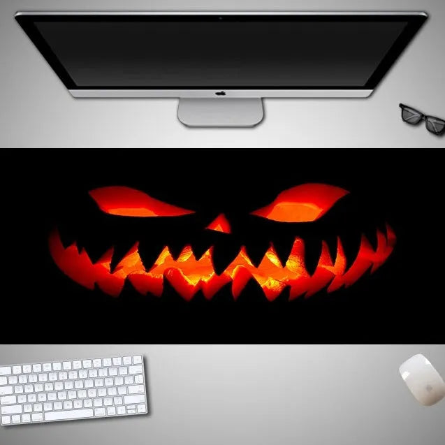 Oversized Halloween graphic cloth mouse pad on a desk, showing non-slip rubber base.