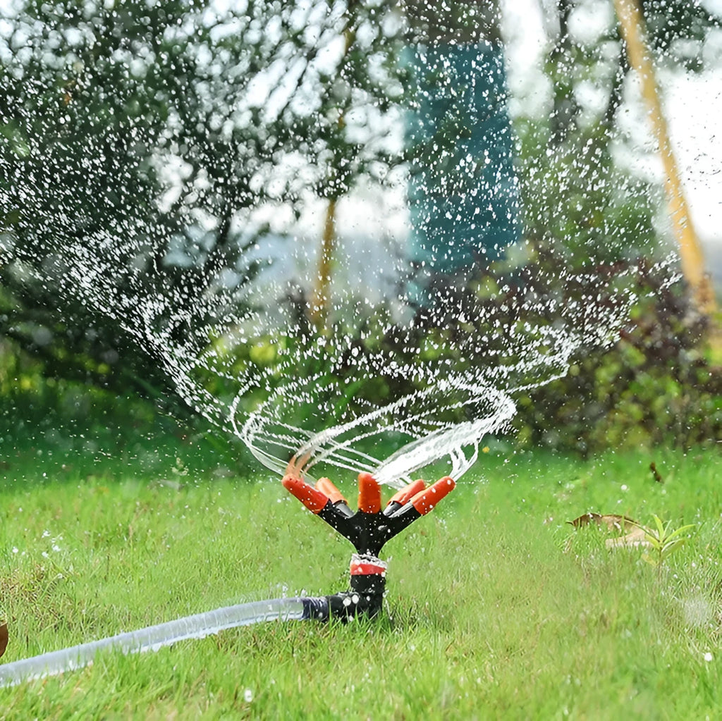 Automatic rotating garden sprinkler in orange plastic, size 14x26.5cm, on green lawn