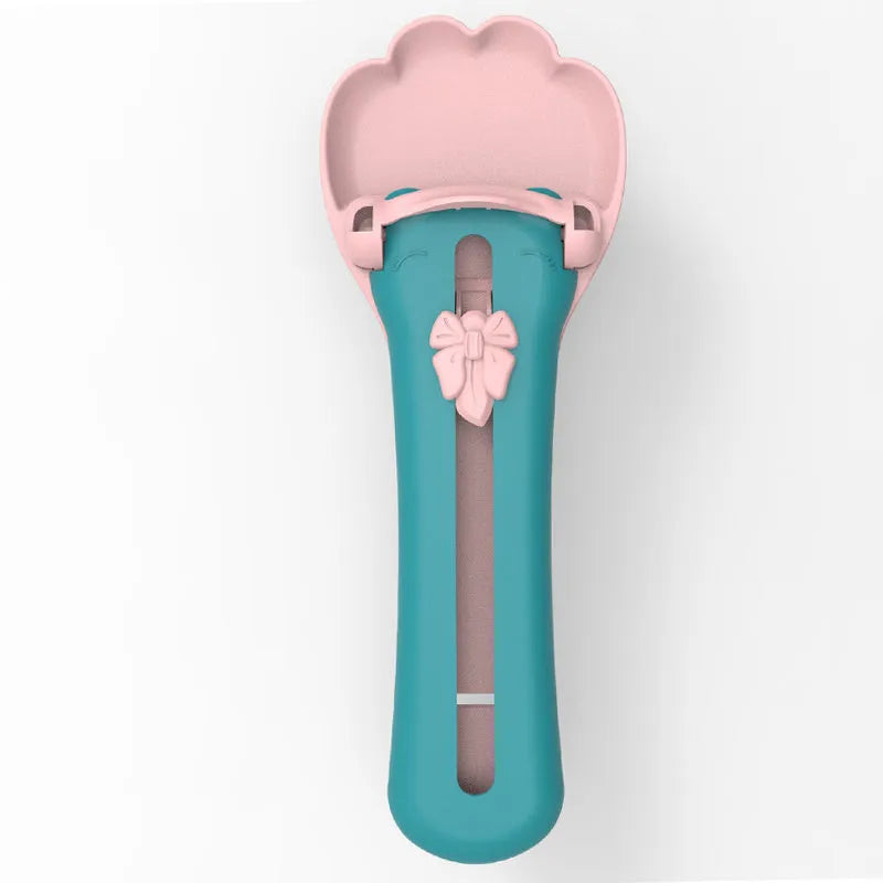 Green and pink pet feed spoon and snack squeezer tool for cat and dog food.