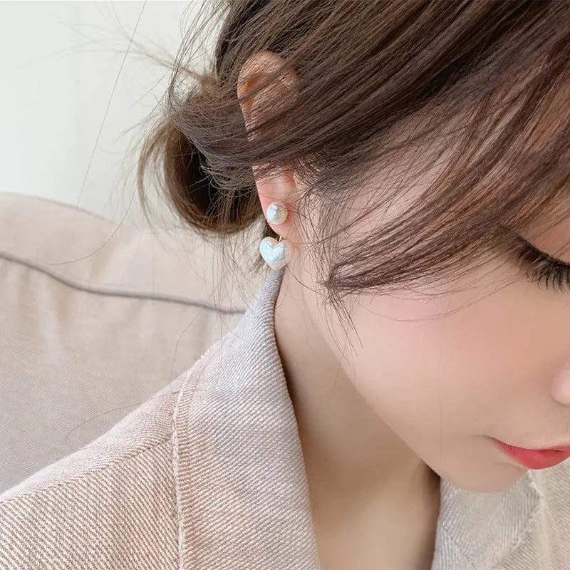 A pair of Korean-style heart-shaped stud earrings with inlaid artificial gems on an alloy base.