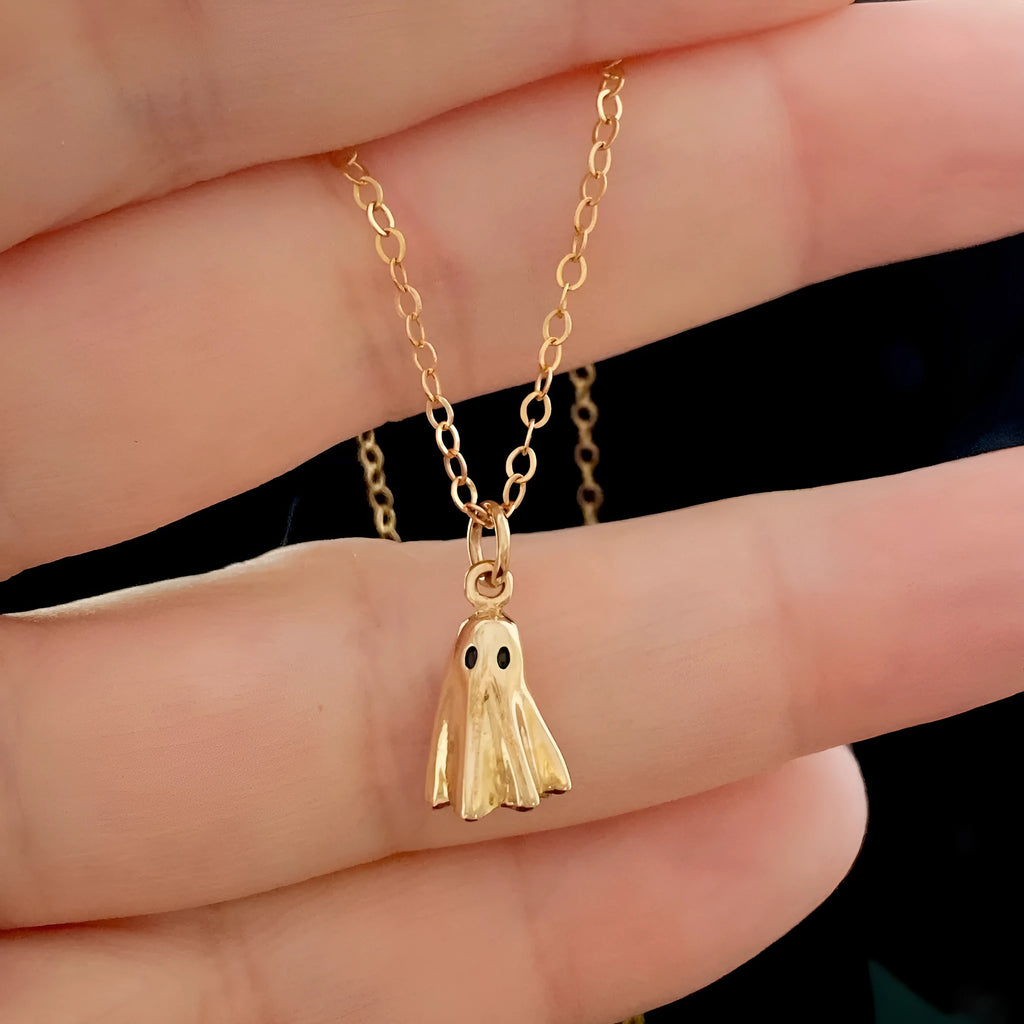 Close-up of a titanium steel ghost pendant on a stainless steel chain necklace.