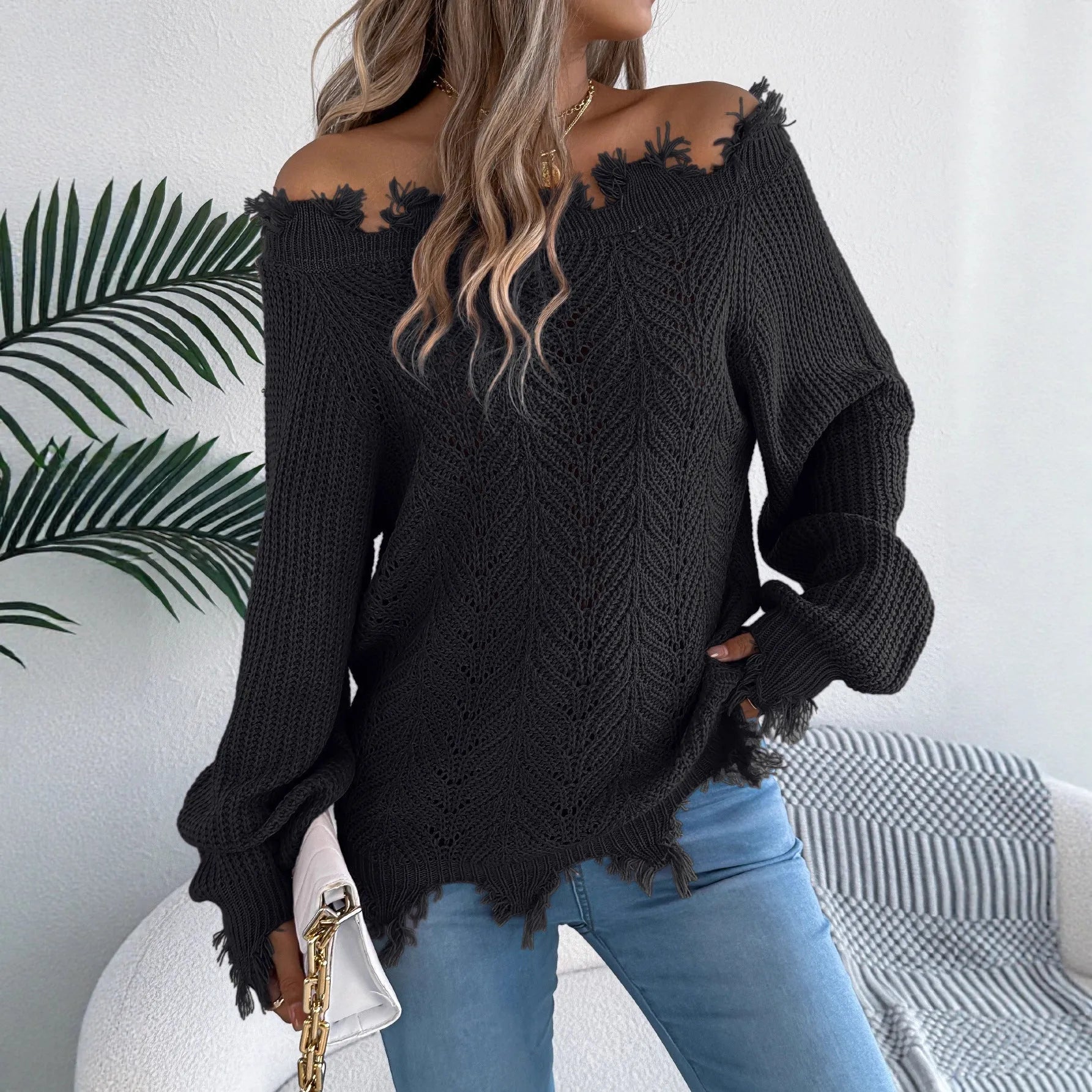White hollow-out off-the-shoulder long sleeve pullover sweater laid flat.