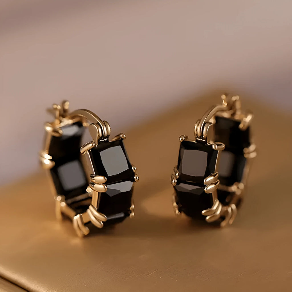 Geometric U-shaped gold-tone earrings with black zircon stones, approximately 20mm diameter