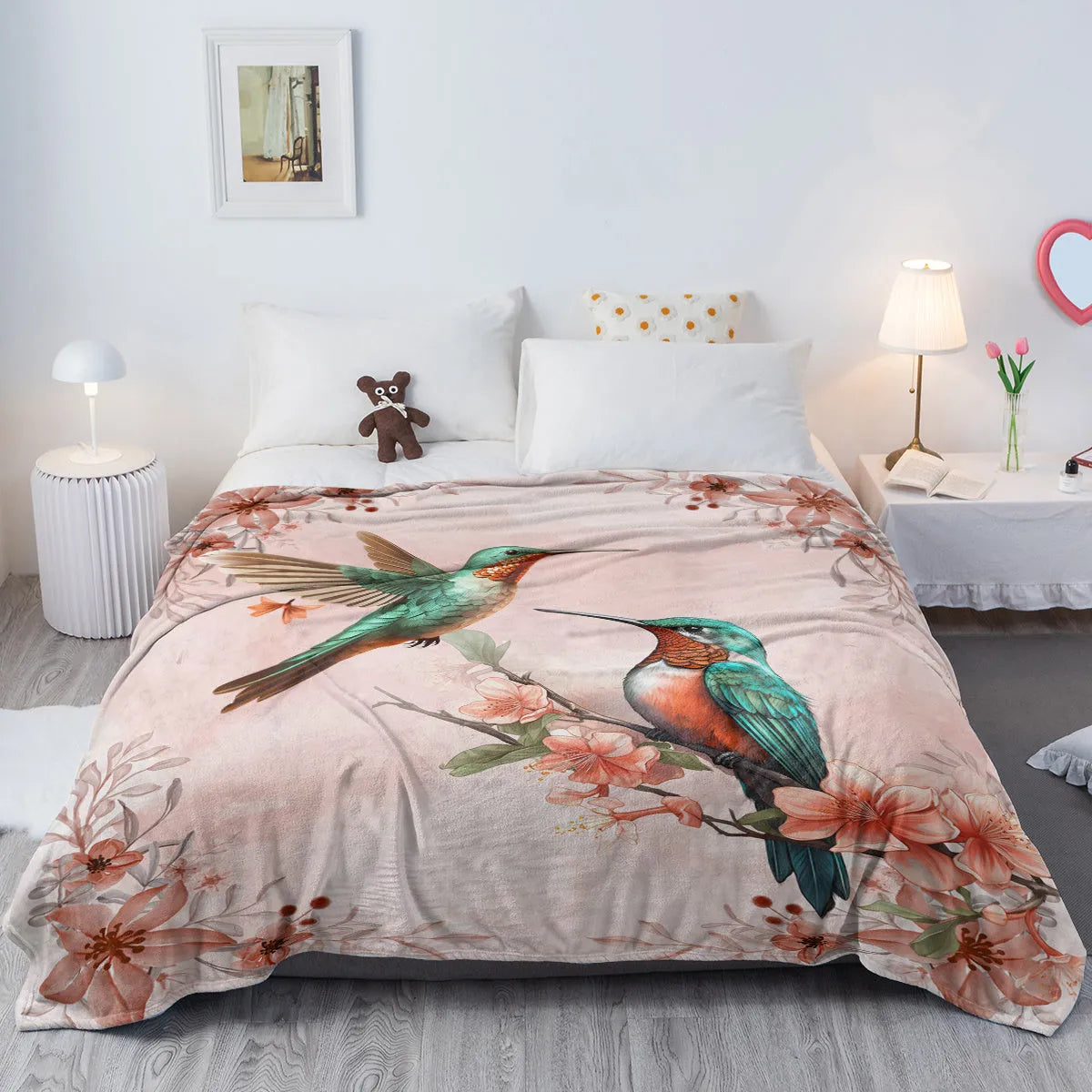Hummingbird floral fleece throw blanket in pink flannel velvet, shown on sofa with hemmed edges