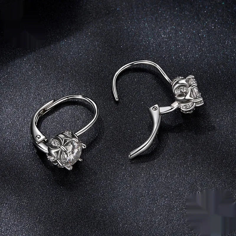 Sterling silver flower bud ear clip with white gold plating and a central moissanite stone.