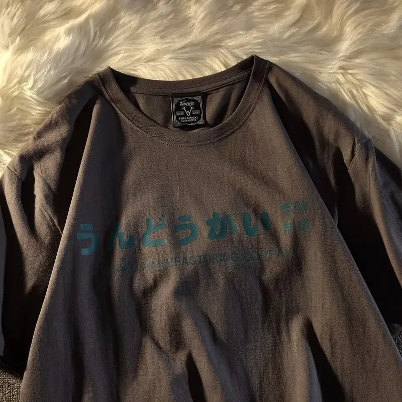 A loose-fitting black cotton t-shirt with a white letter print, shown on a hanger.
