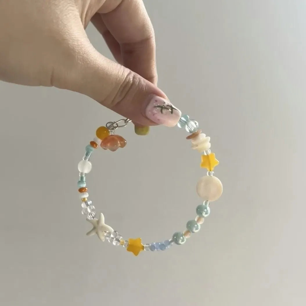Orange and sea tone mixed material bracelet with diamond shapes and round elements
