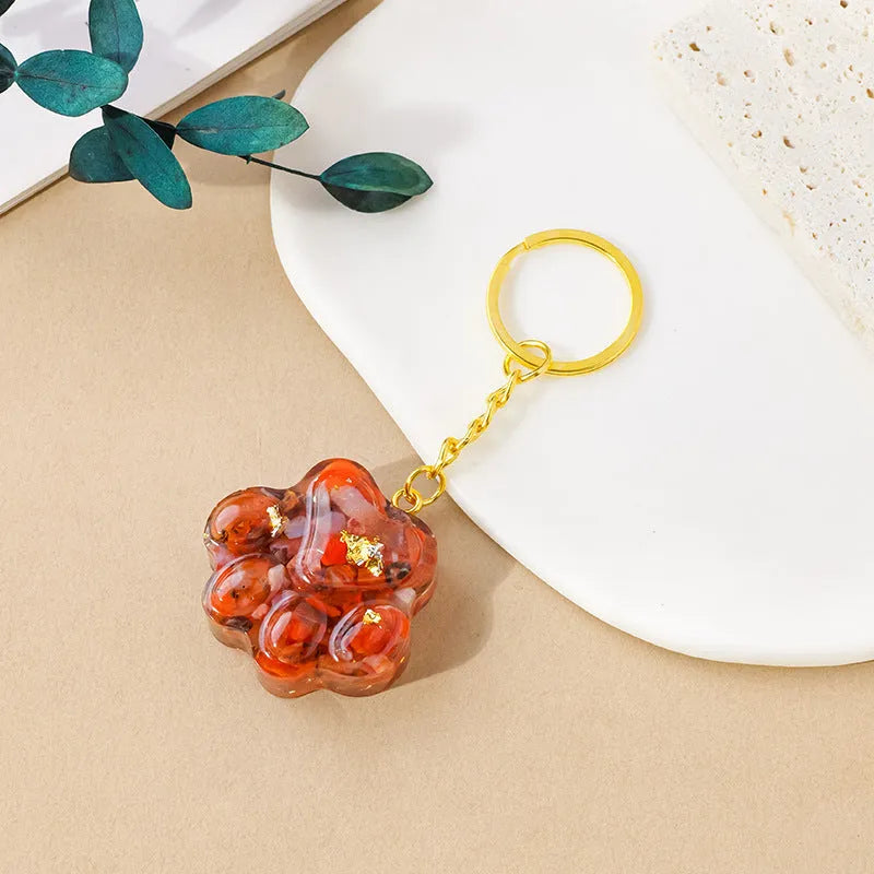 Small natural crystal cat's paw keychain pendant on a metal ring.