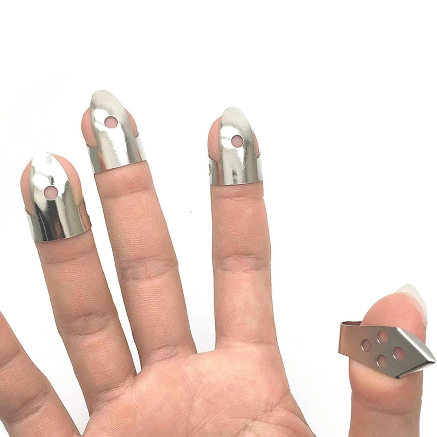 Set of 4 metal guitar finger picks arranged on a dark surface