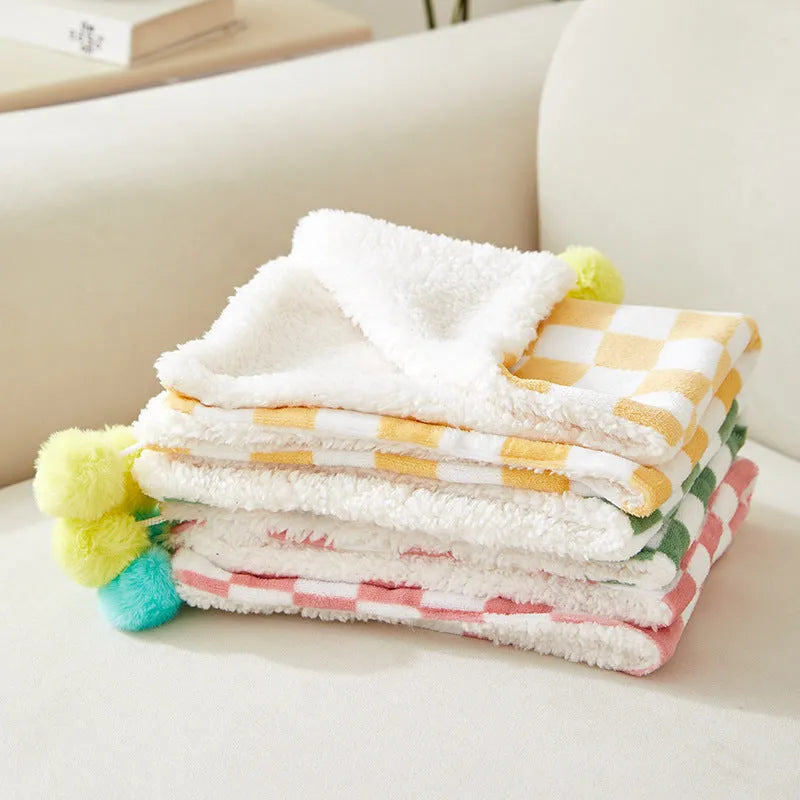 Green plaid pattern plush pet blanket for cats and dogs on a sofa