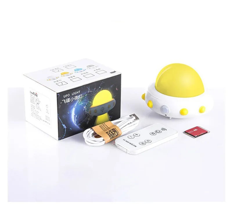 Blue UFO-shaped bedside night light with remote control on a wooden table.