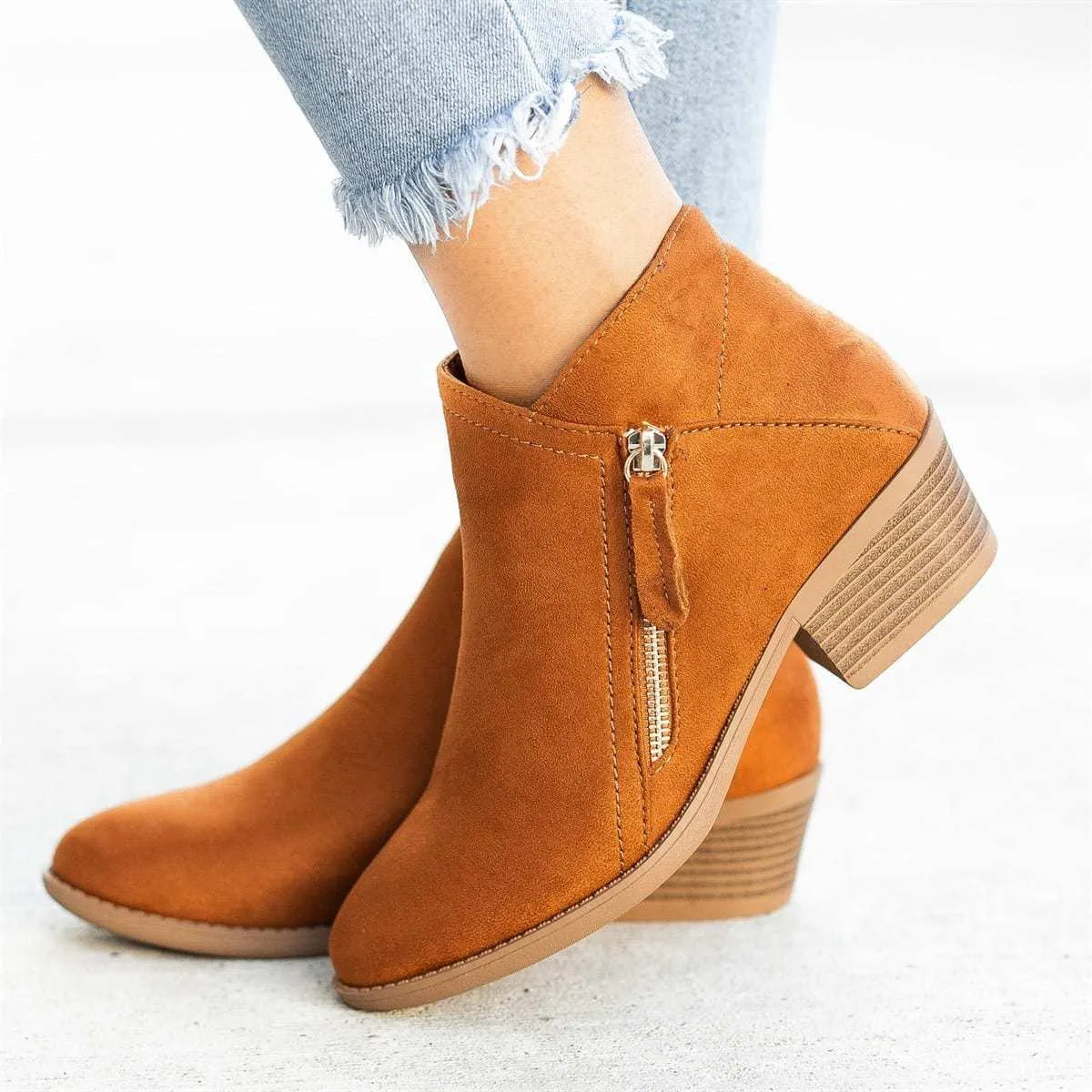 Women's blue suede Dr Martens ankle boots with side zip and chunky heel on a white background.