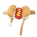 A dog or cat wearing a stuffed brown hot dog costume with bun detail for party cosplay.
