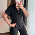 Woman's loose-fit short-sleeve casual top in black polyester fabric on a hanger.