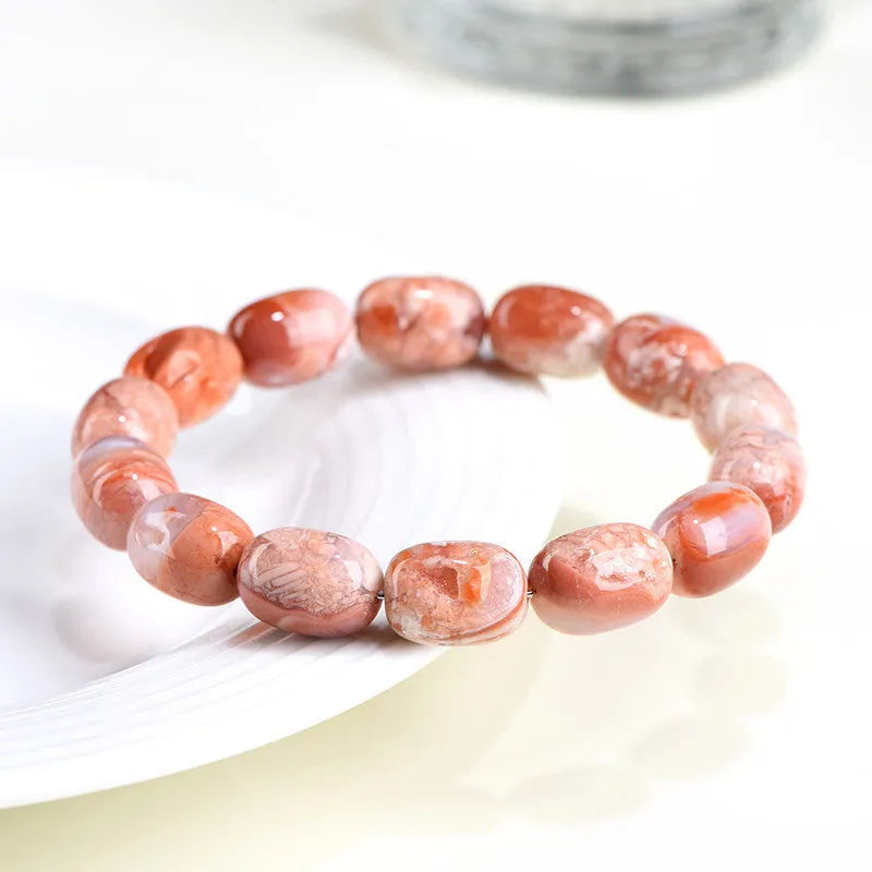 Natural cherry agate barrel bead bracelet with Ruyi decoration on white background