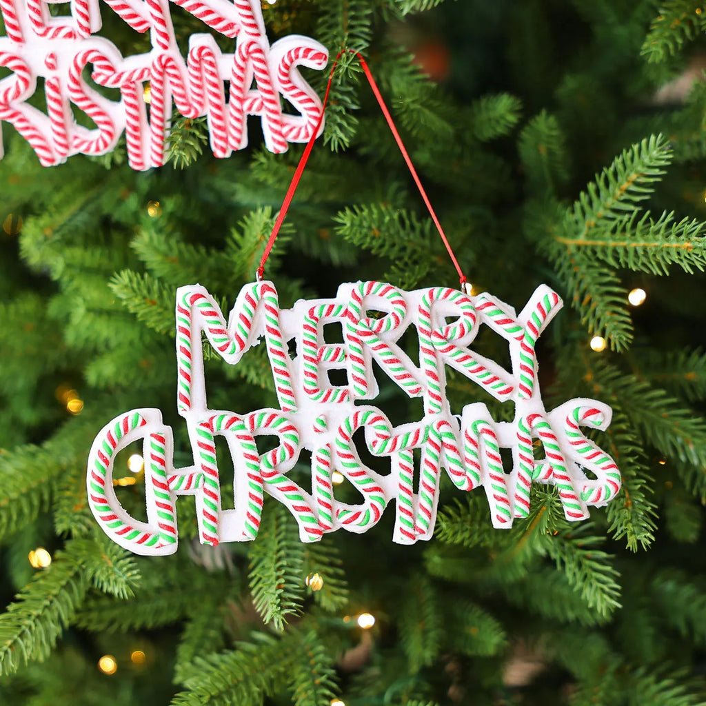 Merry Christmas letter plate polymer clay tree ornament in red, white and green plastic hanging on a tree branch