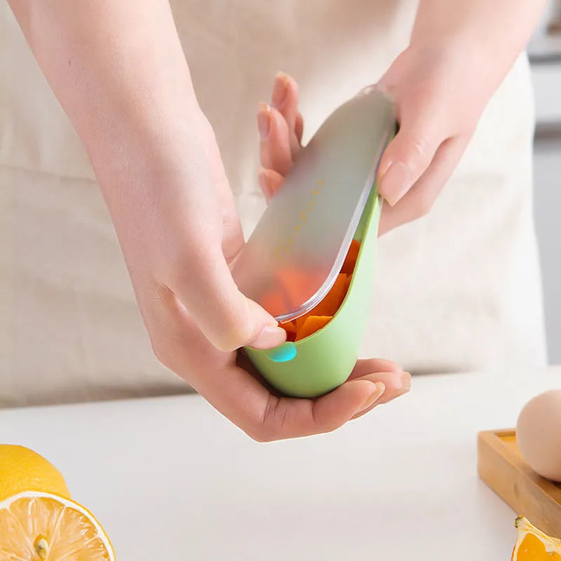 Green vegetable peeler with storage tube, non-slip handle, and hang hole on a kitchen worktop.