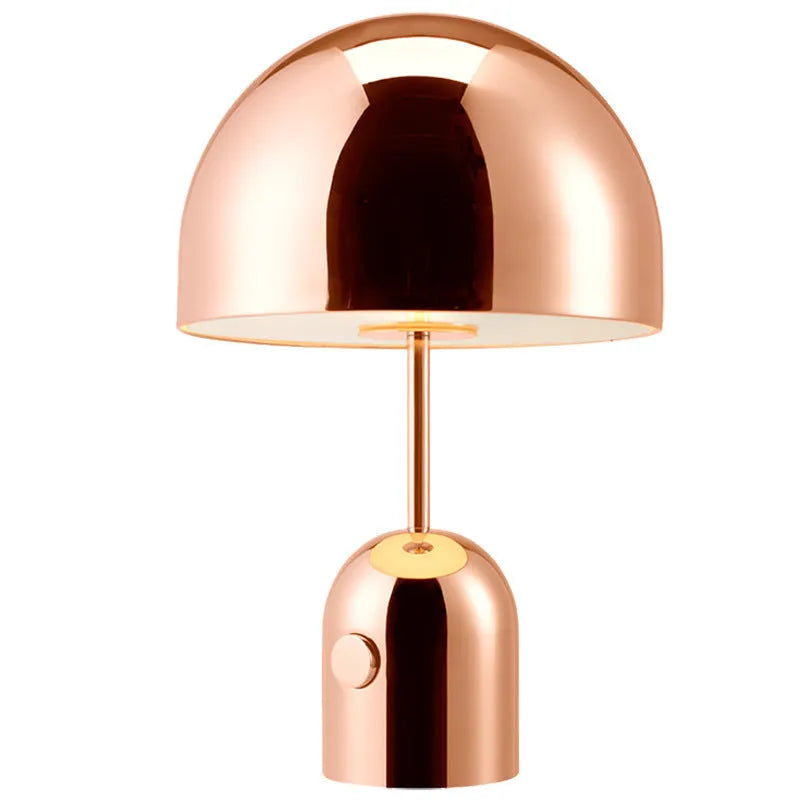 Mushroom-shaped metal table lamp in rose gold finish on wooden surface