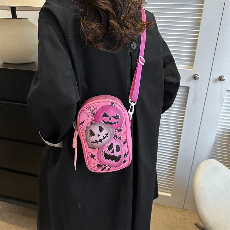 Black mini crossbody phone bag with Halloween graffiti print showing pumpkins, ghosts and bats