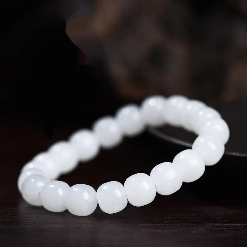 White Hetian jade barrel bead bracelet shown in three bead size variations on a wrist.