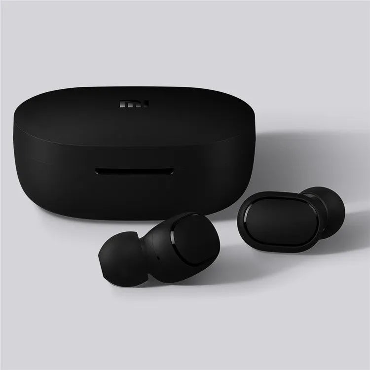 Redmi AirDots black true wireless earbuds next to their white charging case.