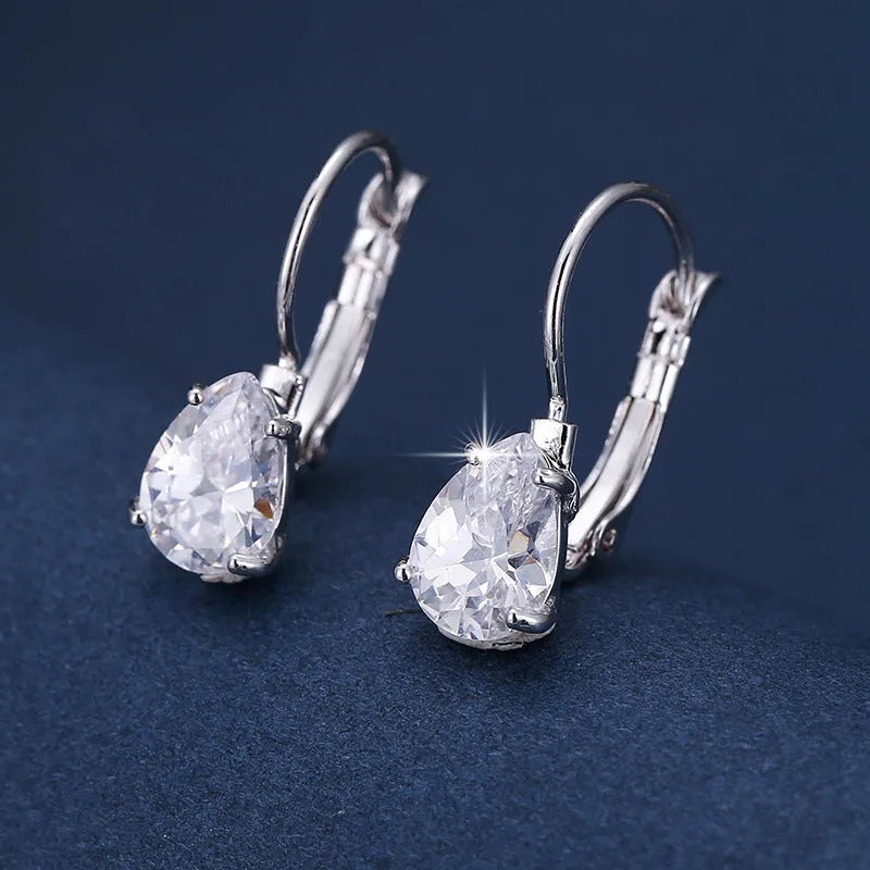 A pair of women's drop-shaped fashion earrings in gold or platinum finish with a platinum-inlaid gemstone.