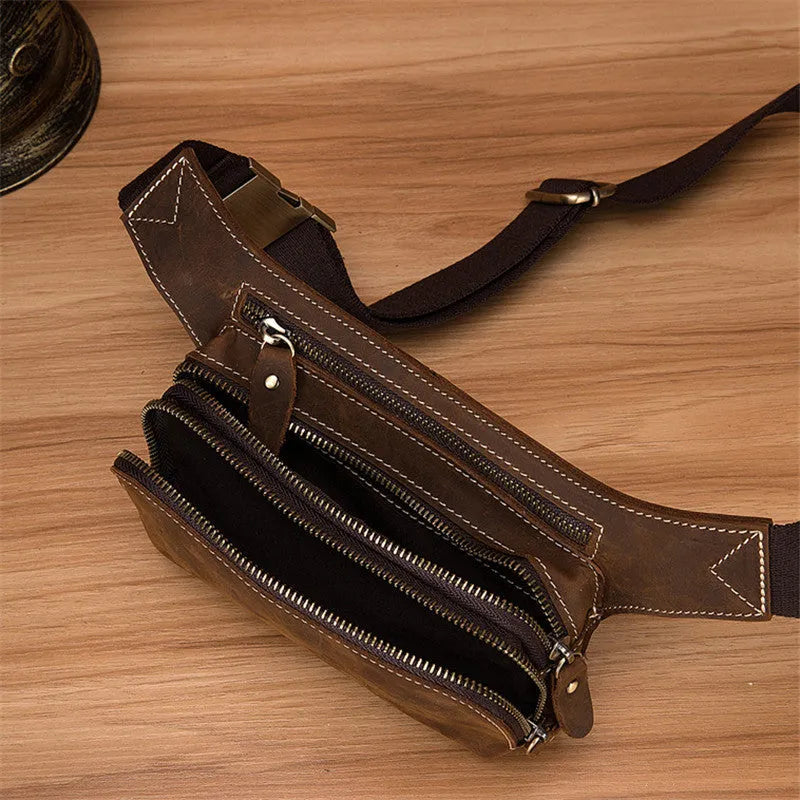 Brown cowhide leather men's sports waist bag with pull closure, shown with phone and laptop compartments.