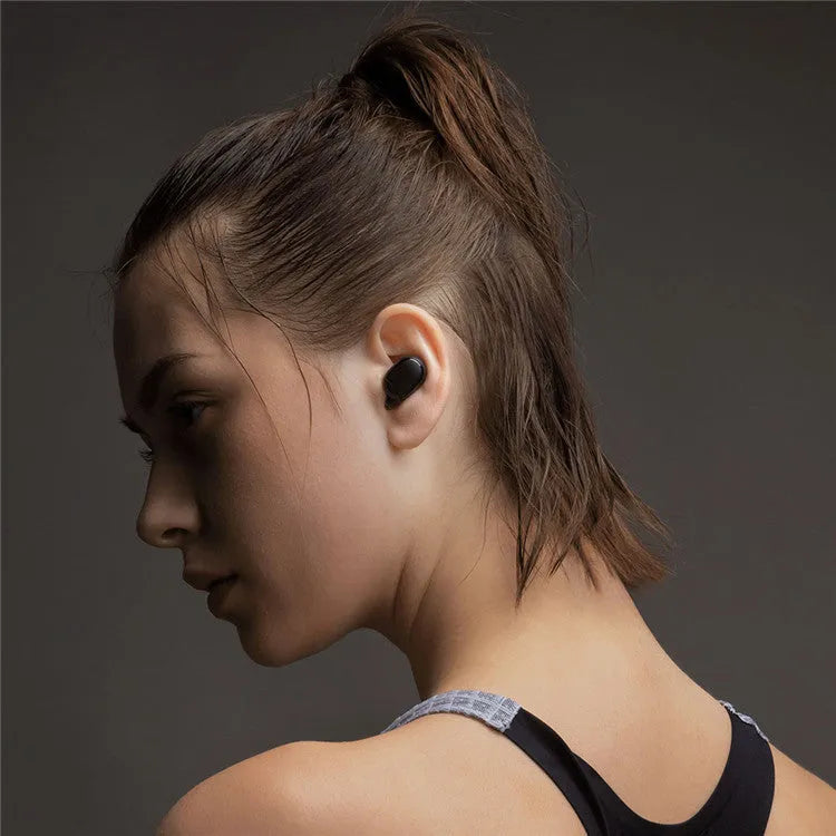 Redmi AirDots black true wireless earbuds next to their white charging case.