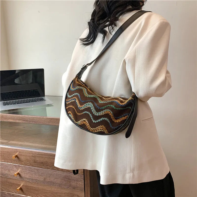 Women's knitted straw woven crossbody bag showing woven texture and internal phone compartment