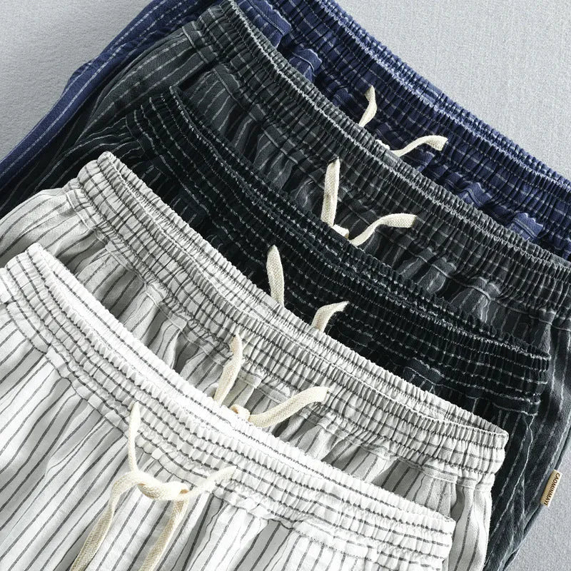 Man wearing black and white striped loose-fit casual cotton shorts with a mid waist.