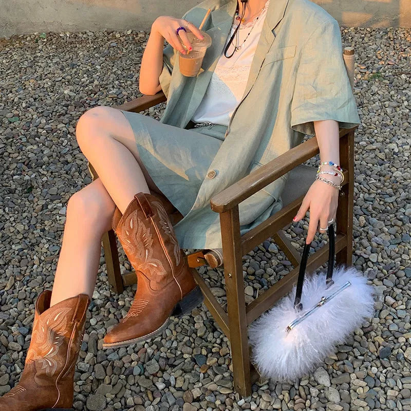 Brown women's Martin boots with embroidered toe cap and mid-calf height.
