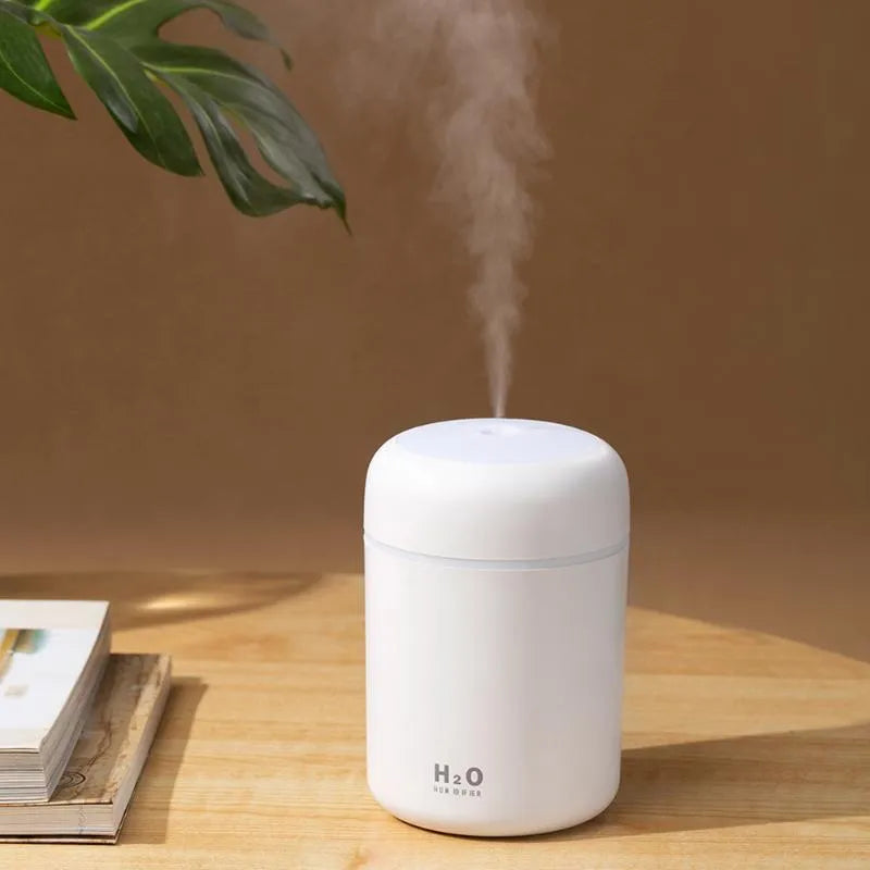 Pink USB desktop humidifier with colourful LED lights and 300ml water tank on wooden desk