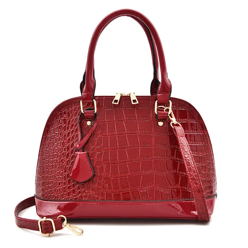 Shiny black PU crossbody bag showing structured shell shape and dimensions