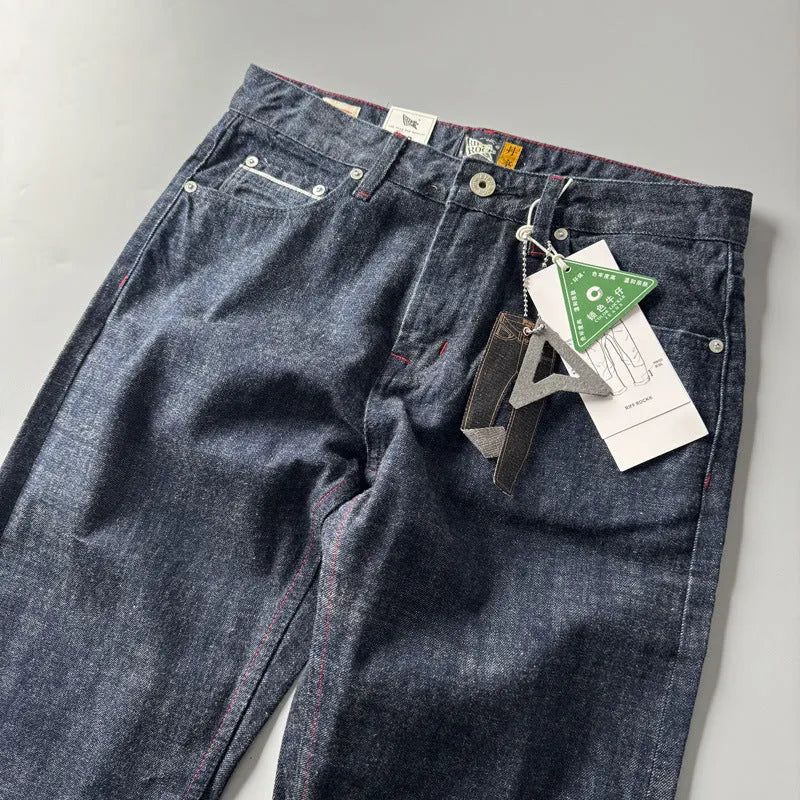 Men's primary colour straight leg denim jeans laid flat, showing mid waist and classic five-pocket design.